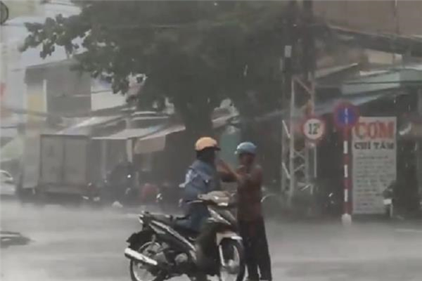 Cảm động hình ảnh người đàn ông đội cả cơn mưa nhường áo cho con trai giữa ngã tư đường phố