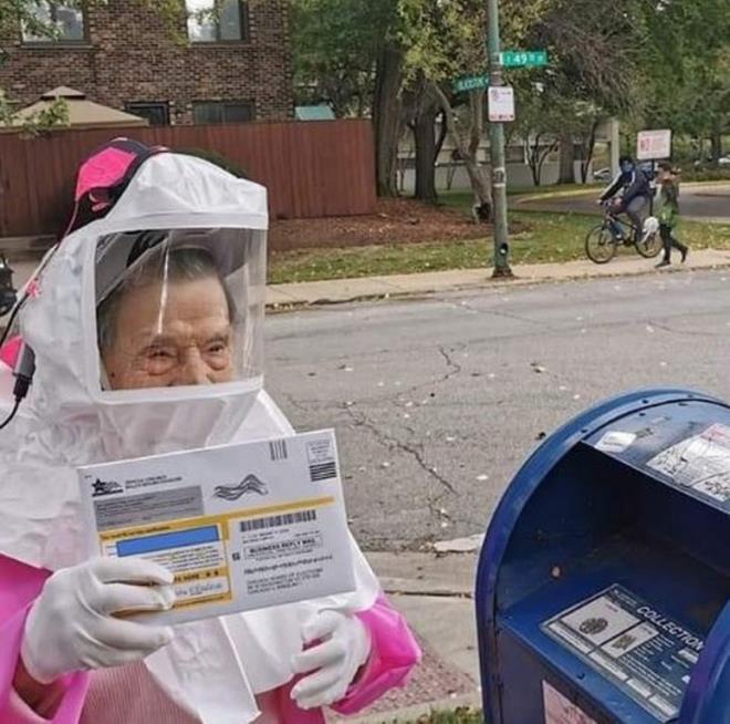 Cụ bà 102 tuổi mặc đồ bảo hộ COVID-19 đi bỏ phiếu