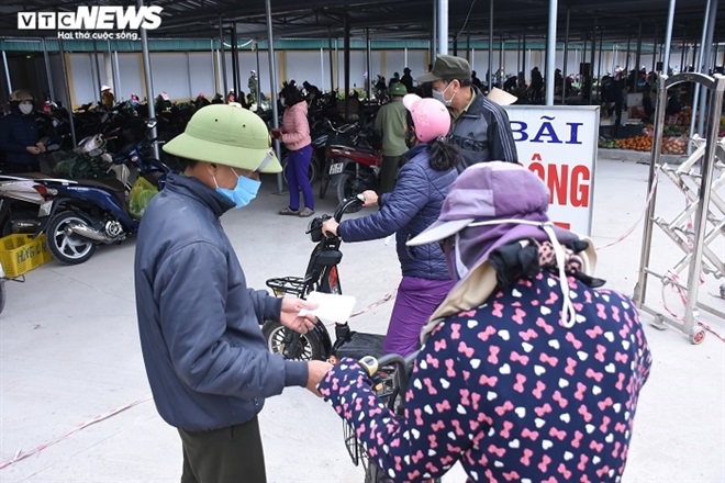 Ảnh: Người dân tâm dịch Chí Linh mang tem phiếu đi chợ theo ngày chẵn - lẻ